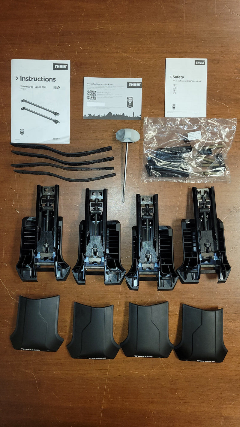 Load image into Gallery viewer, Set of black plastic components and tools on a wooden surface with instructions and safety cards.