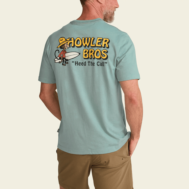 Load image into Gallery viewer, Person wearing a light blue t-shirt with 'Howler Bros' logo on the back, standing against a beige background.
