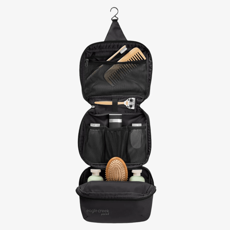 Load image into Gallery viewer, Black hanging toiletry bag with grooming products on a white background
