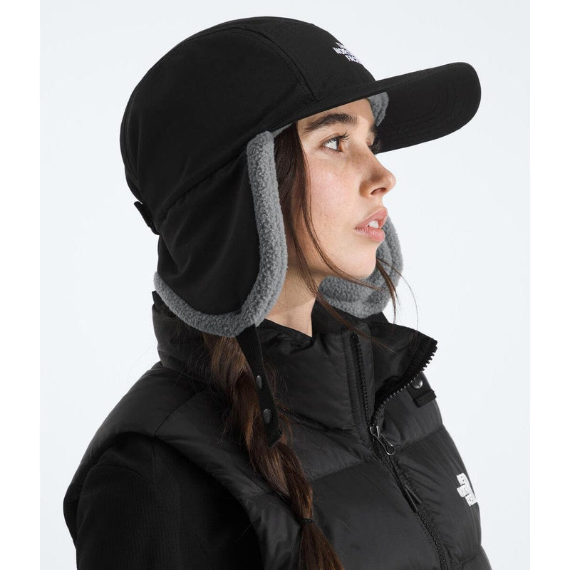 Load image into Gallery viewer, Person wearing a black cap with ear flaps and a black jacket on a white background