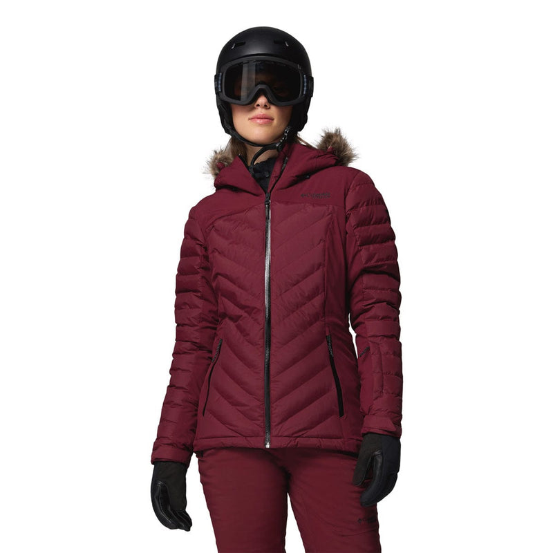 Load image into Gallery viewer, Person wearing a maroon winter jacket, helmet, and goggles on a white background