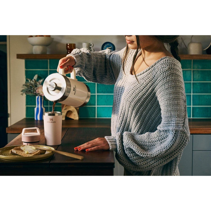Load image into Gallery viewer, Person pouring coffee from a French press into a mug in a kitchen.
