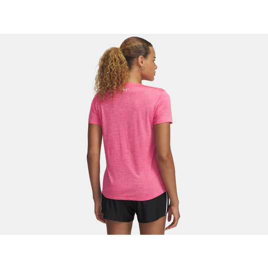 Woman wearing a pink athletic shirt and black shorts on a white background