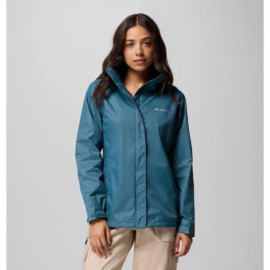 Woman wearing a blue jacket with a visible brand logo on a gray background