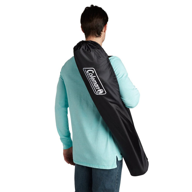 Load image into Gallery viewer, Person carrying a black Coleman travel bag on a white background
