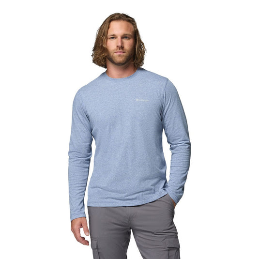 Man wearing a blue long-sleeve shirt and gray pants on a white background