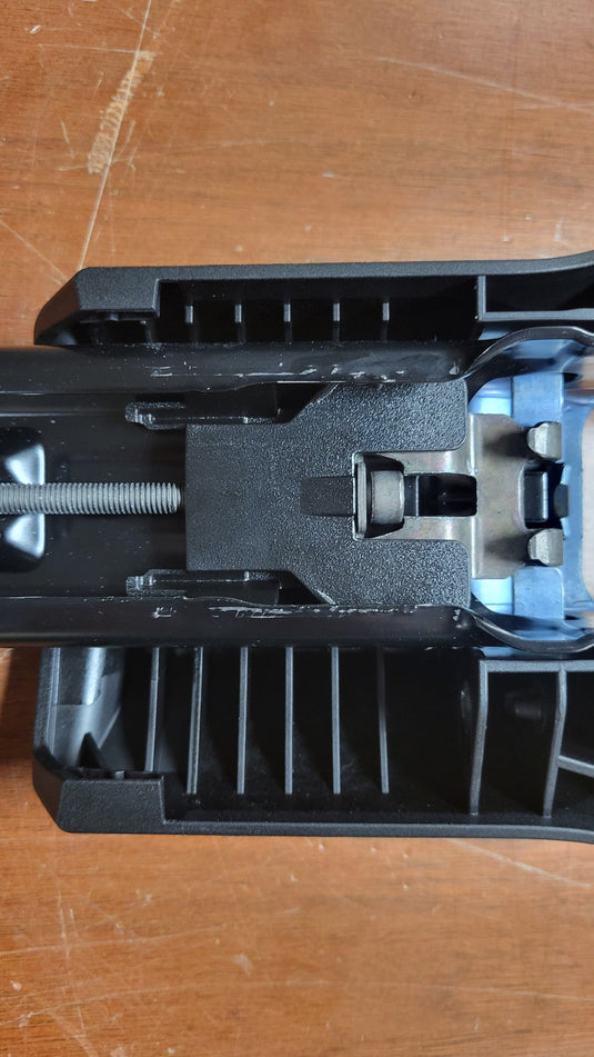Black plastic component on a wooden surface