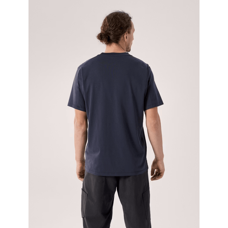 Load image into Gallery viewer, Man wearing a navy blue t-shirt and dark pants on a light gray background
