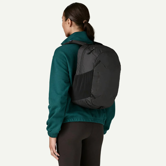Person wearing a black backpack on a white background