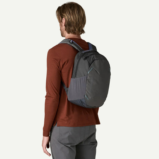 Person wearing a gray patagonia backpack on a white background