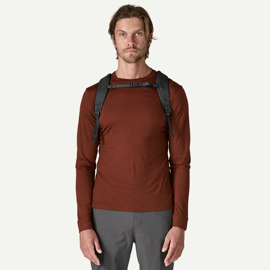 Man wearing a dark grey backpack on a white background