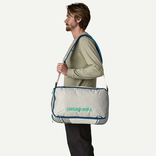 Man carrying a white Patagonia bag with a blue trim 