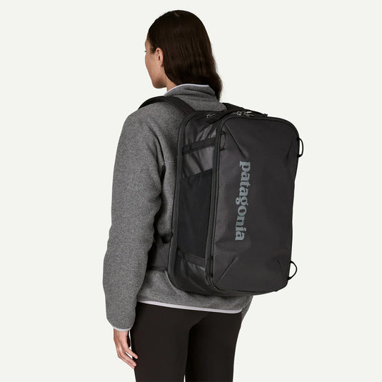 Person wearing a black Patagonia backpack on a white background