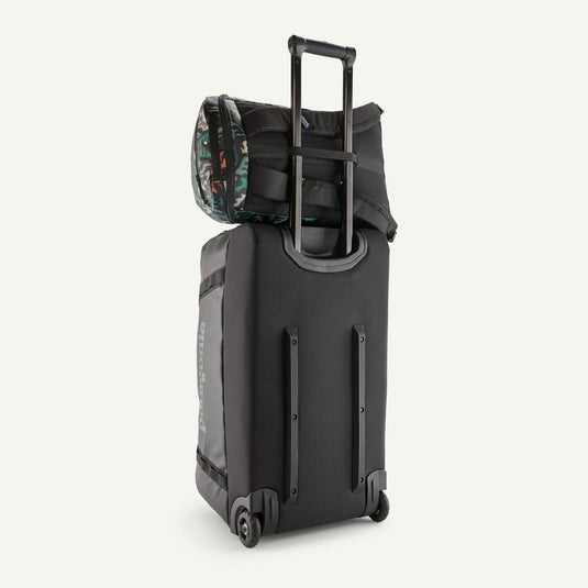 Black rolling suitcase with a camouflage-patterned bag on top against a white background