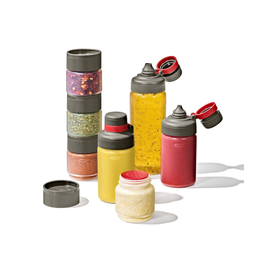 Set of colorful spice jars with various spices on a white background