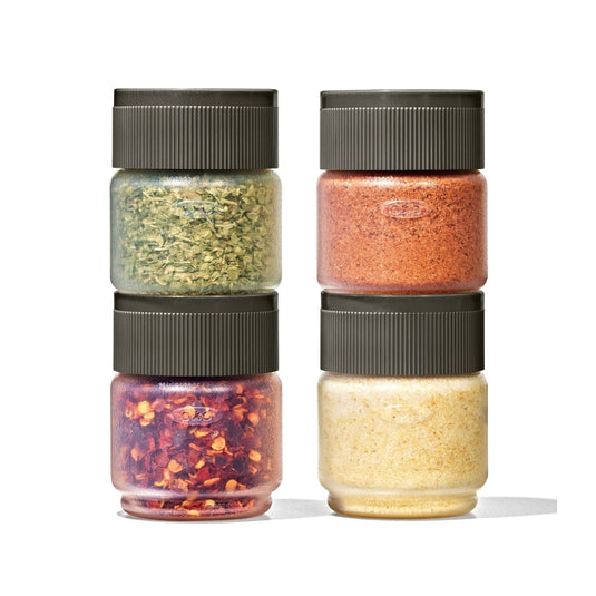 Set of four spice jars with different spices on a white background