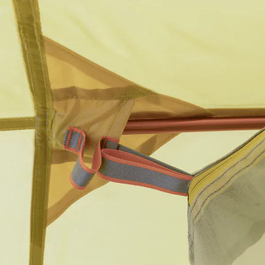 Close-up of a tent's mesh side panel with a zipper and strap.