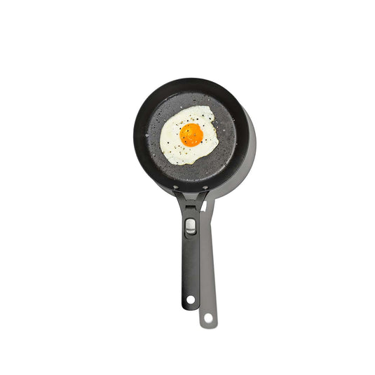 Small frying pan with a fried egg on a white background