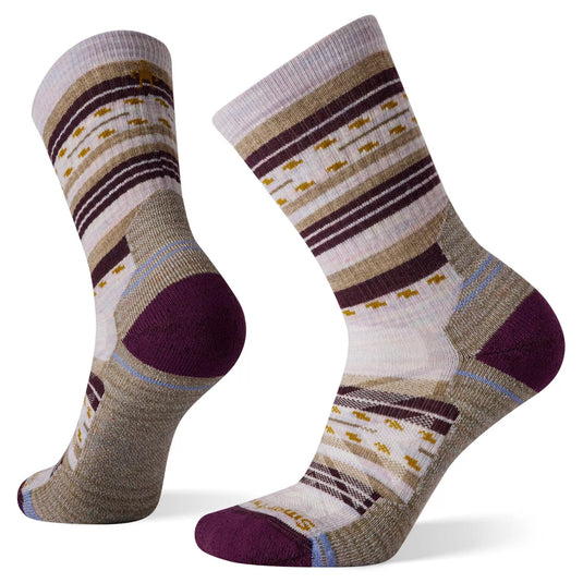 A pair of Smartwool women's crew socks with a striped pattern featuring a mix of beige, purple, and gray colors, and a small, decorative pattern design.