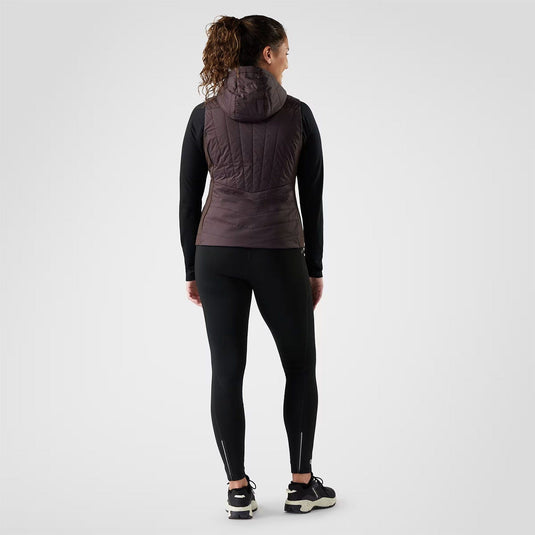 Person wearing a black athletic outfit with a hooded jacket on a white background