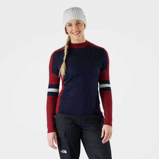 Person wearing a navy and red sweater with black pants on a white background
