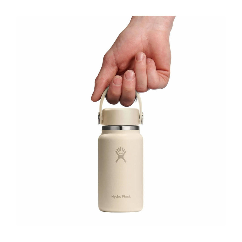 Load image into Gallery viewer, Beige Hydro Flask bottle held by a hand on a white background
