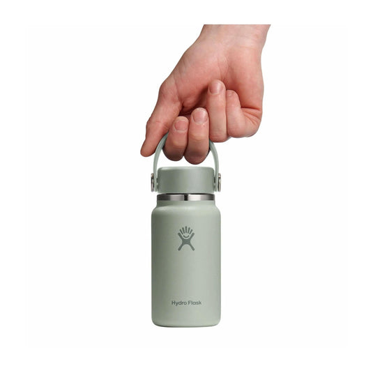 Hand holding a light green Hydro Flask bottle on a white background
