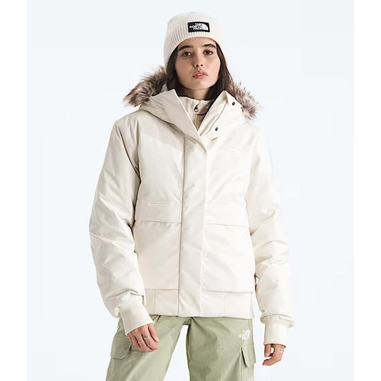 Person wearing a white winter jacket with fur hood and matching hat on a white background