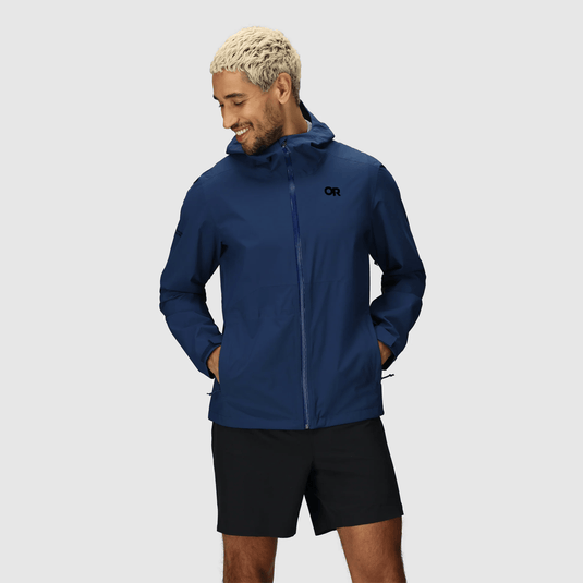 Man wearing a blue jacket with a hood on a gray background