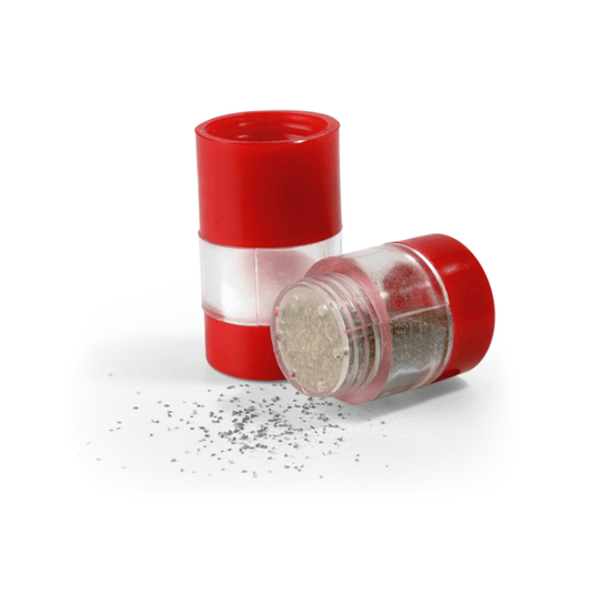 Red and clear pepper grinder with pepper on a white background