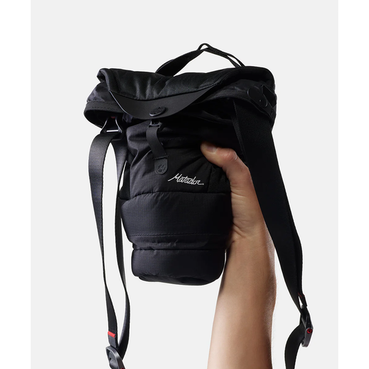 Black backpack held by a hand on a white background