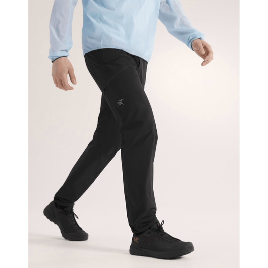 Person wearing black pants and a light blue shirt on a white background