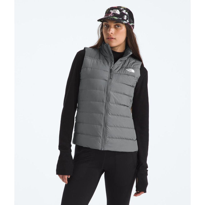 Load image into Gallery viewer, Woman wearing a gray puffer vest with a brand logo on a white background
