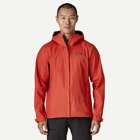 Person wearing a red rain jacket with a visible brand logo on a white background