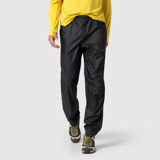 Person wearing black pants and a yellow top on a light gray background