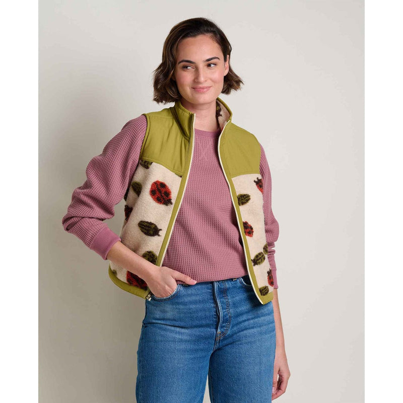 Load image into Gallery viewer, Woman wearing a colorful vest with a pattern, pink shirt, and blue jeans on a plain background
