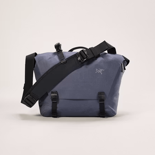 Blue bag with black straps on a light beige background