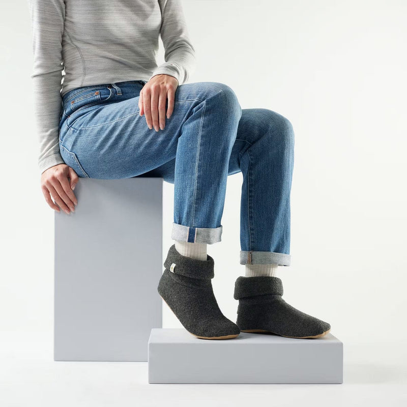 Load image into Gallery viewer, Person wearing gray slippers sitting on a white block with a plain background
