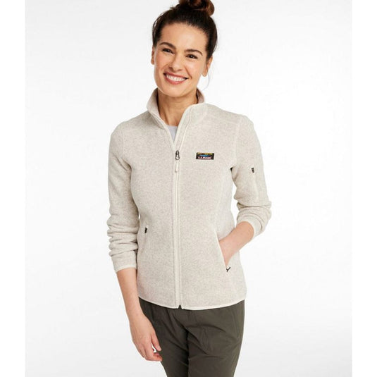 Woman wearing a light gray fleece jacket with a visible brand logo on a white background