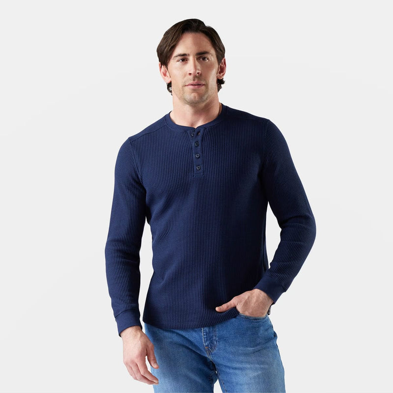 Load image into Gallery viewer, Man wearing a navy blue long-sleeve henley shirt and jeans on a light gray background
