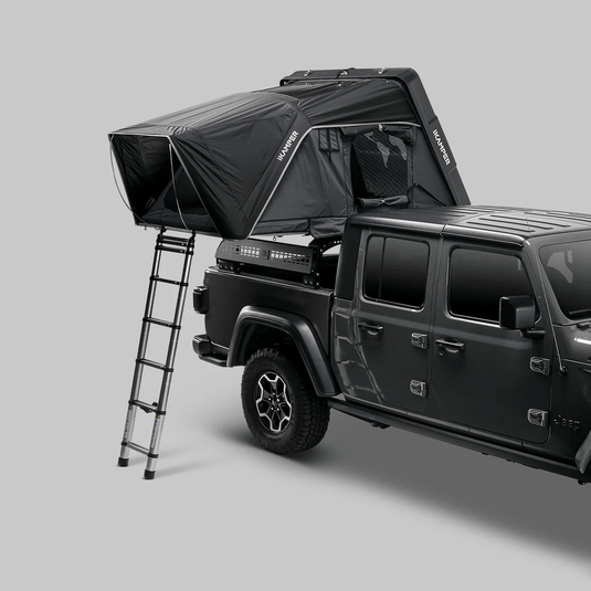 Black rooftop tent on a Jeep Wrangler against a gray background
