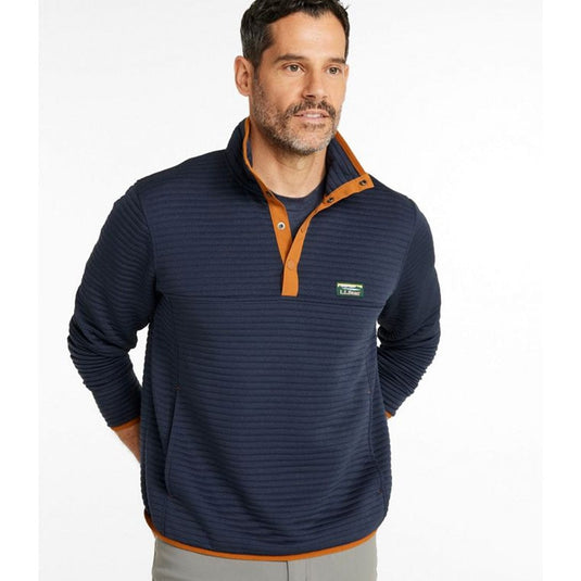 Man wearing a navy pullover with orange accents on a white background