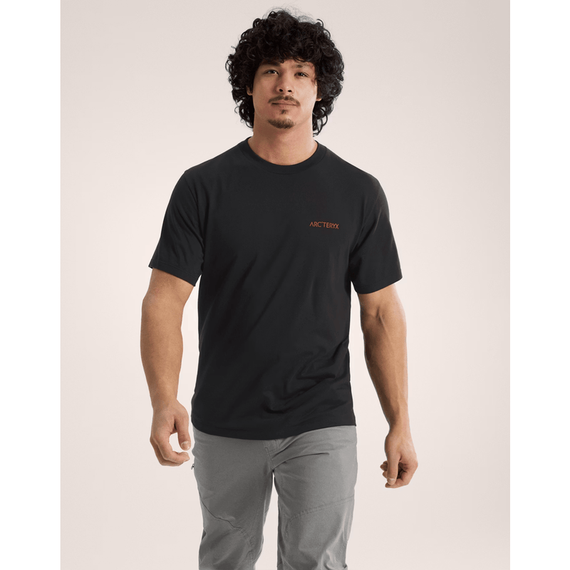 Load image into Gallery viewer, Man wearing a black t-shirt with a red logo on a plain background
