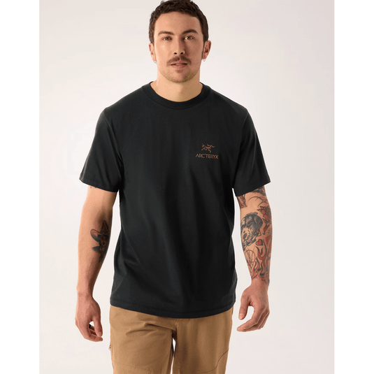 Man wearing a black t-shirt with a logo on a white background