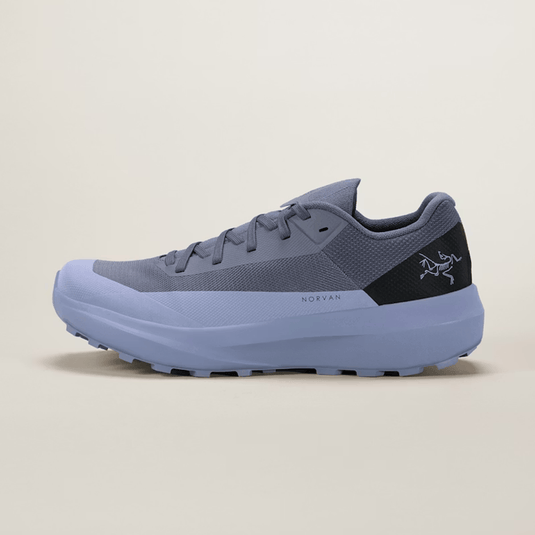 Blue athletic shoe with a black accent on a beige background