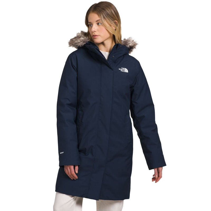 Load image into Gallery viewer, Woman wearing a navy blue coat with fur-lined hood on a white background
