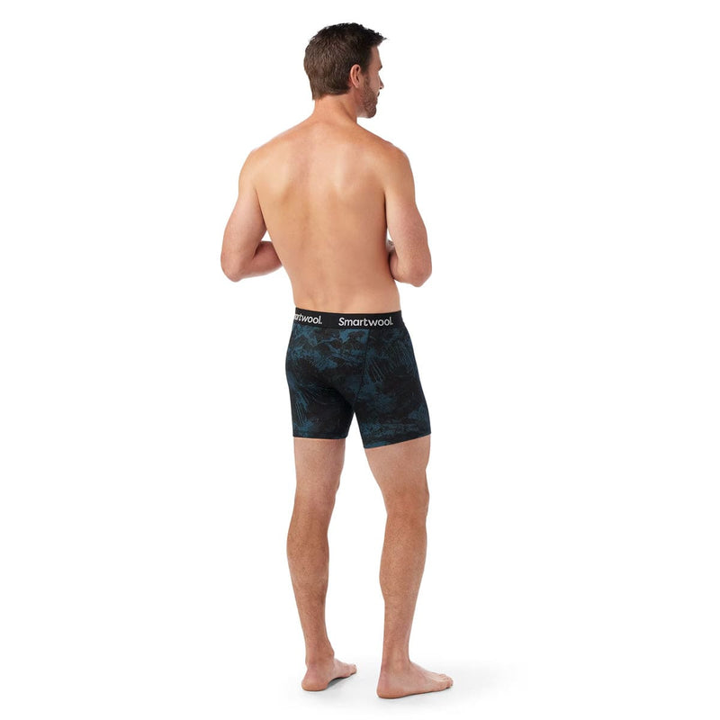Load image into Gallery viewer, Man wearing black patterned boxer briefs with 'Smartwool' branding on a white background
