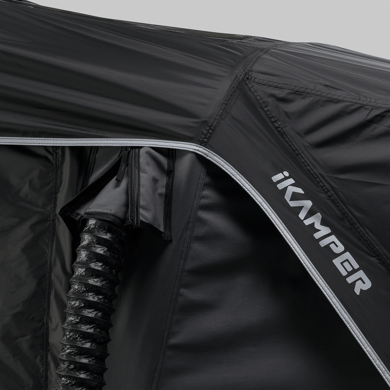 Load image into Gallery viewer, Close-up of a black rooftop tent with 'ikamper' branding on a gray background
