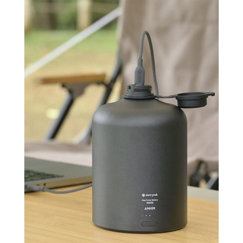 Load image into Gallery viewer, Black portable power station on a table with a laptop in the background
