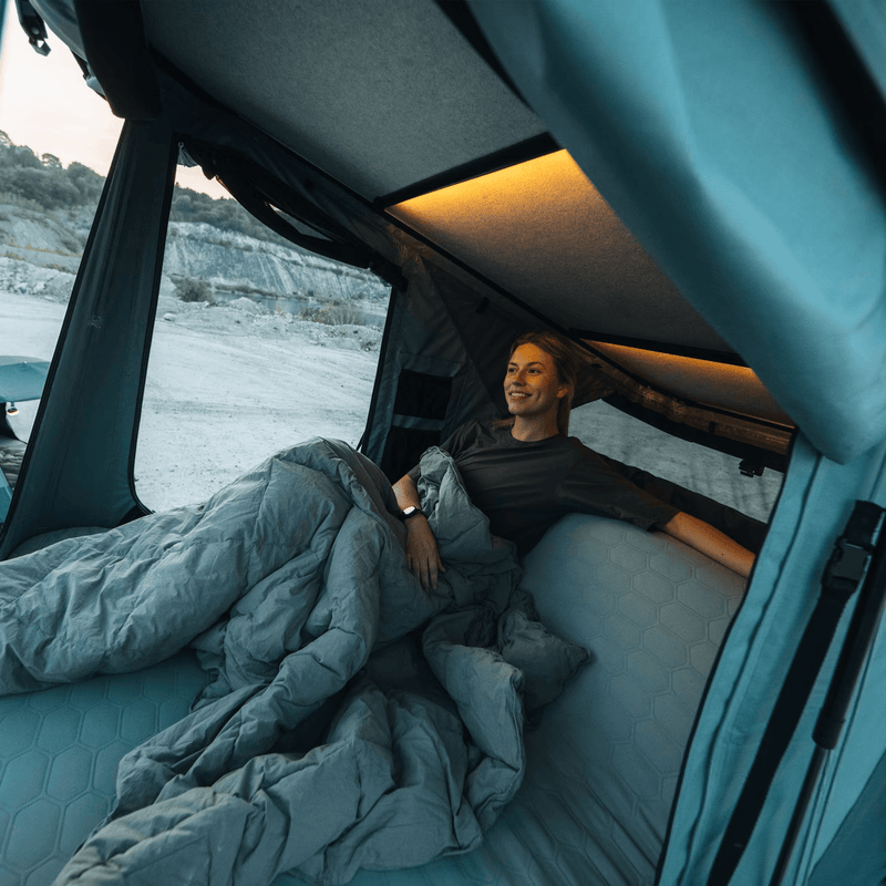 Load image into Gallery viewer, Person lying in a van bed with a scenic view outside
